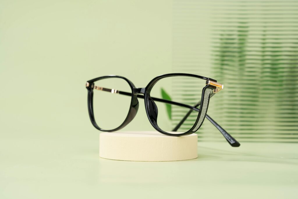 pexels photo 28065039 28065039 1 Modern black eyeglasses with a classic design resting on a minimalist display stand.