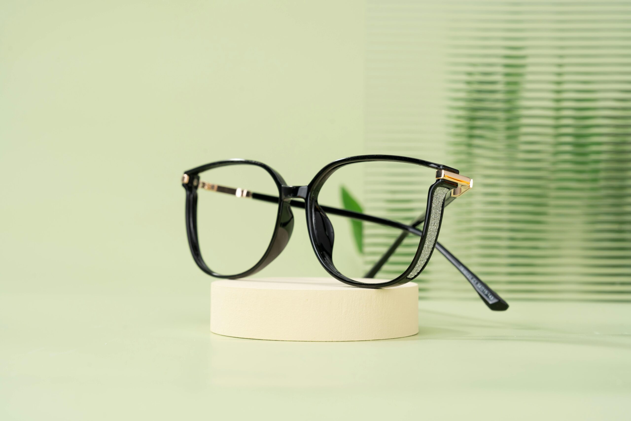 pexels photo 28065039 28065039 Modern black eyeglasses with a classic design resting on a minimalist display stand.